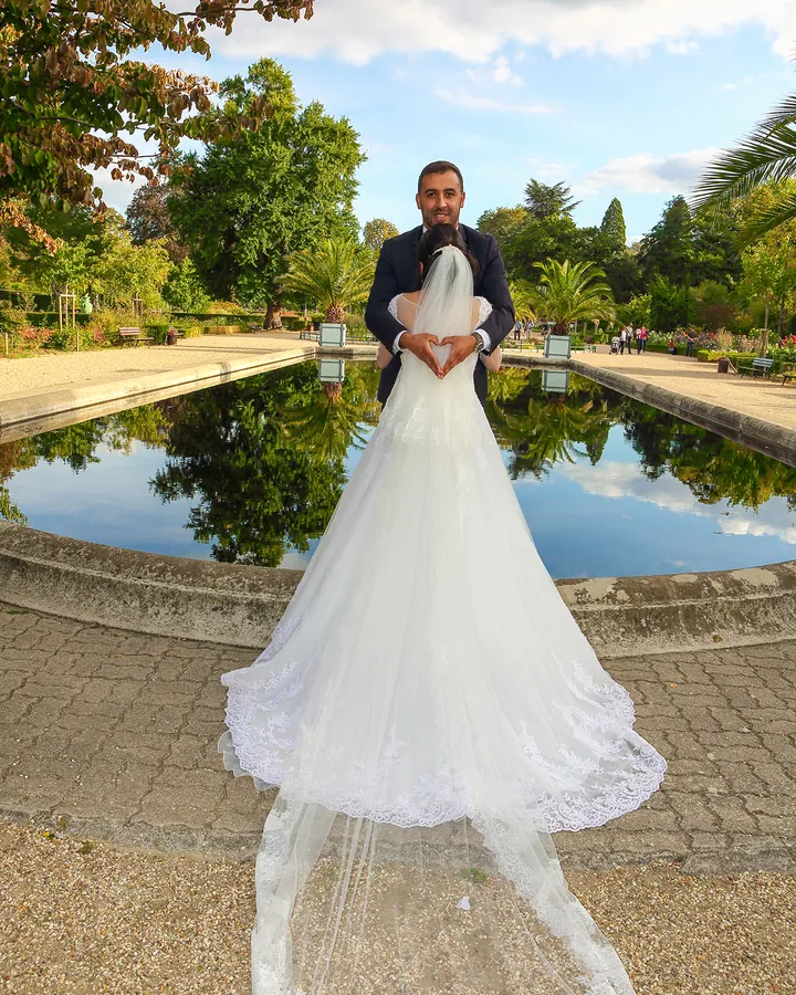 Mariée devant un bassin de jardin à la française