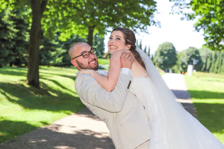 Marié qui rit dans les bras de sa mariée